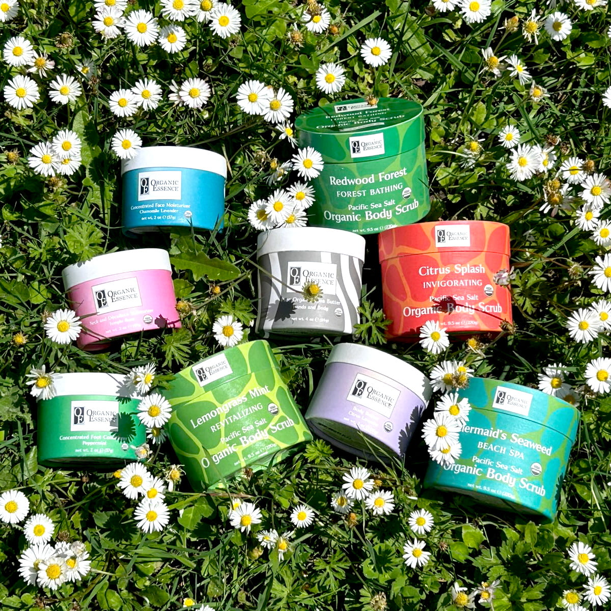 vegan organic skincare products displayed on flowering lawn — certified organic by Organic Essence